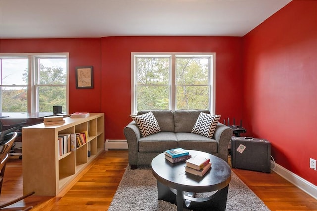 living room featuring hardwood / wood-style flooring, a baseboard radiator, and plenty of natural light