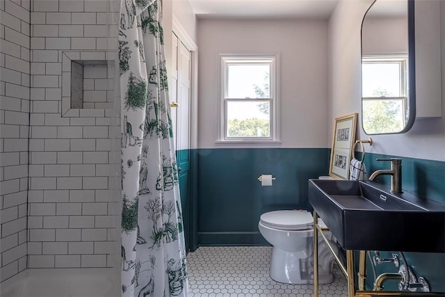 bathroom with a shower with shower curtain, tile patterned flooring, toilet, and sink