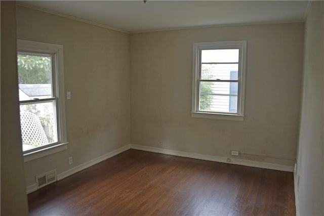 spare room with dark hardwood / wood-style flooring and crown molding