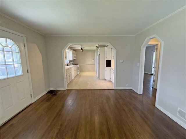 entryway with wood-type flooring, crown molding, and sink