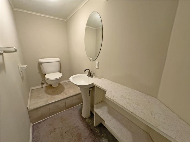 bathroom featuring toilet, ornamental molding, and sink