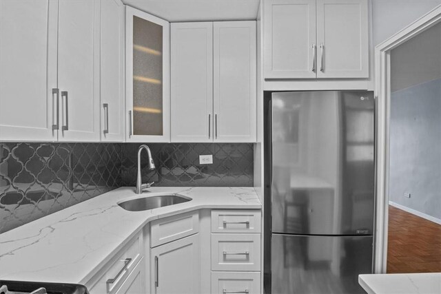 2575 Palisade Ave Unit 2J, Bronx, NY 10463 - kitchen featuring freestanding refrigerator, a sink, white cabinetry, light stone countertops, and tasteful backsplash