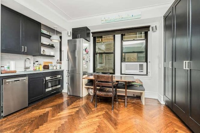 kitchen with dark parquet floors, sink, appliances with stainless steel finishes, and tasteful backsplash