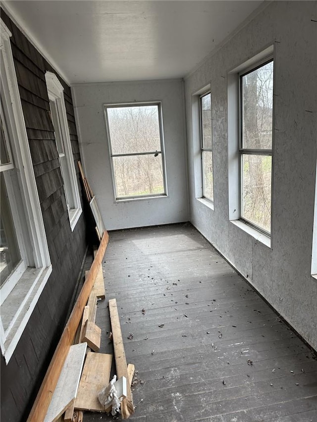 unfurnished living room featuring dark hardwood / wood-style floors and a healthy amount of sunlight