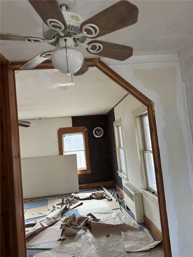 misc room featuring radiator heating unit and brick wall