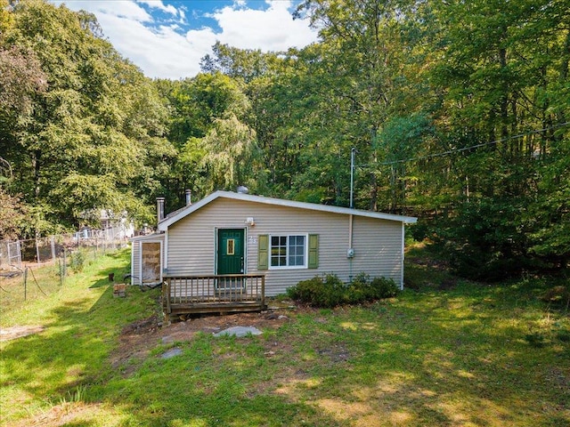 rear view of house featuring a yard and a deck