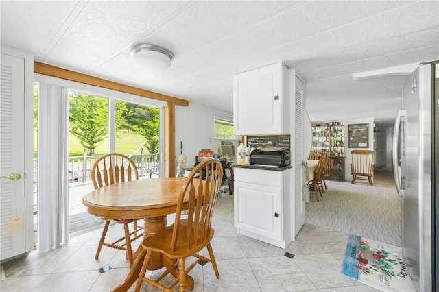 tiled dining space featuring a textured ceiling