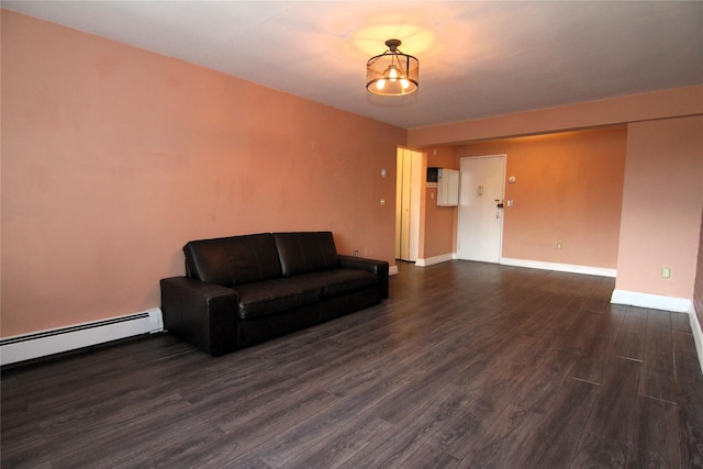 living room featuring dark wood-type flooring, a baseboard radiator, and an inviting chandelier