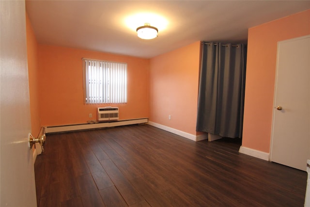 spare room with baseboard heating, dark wood-type flooring, and a wall mounted air conditioner