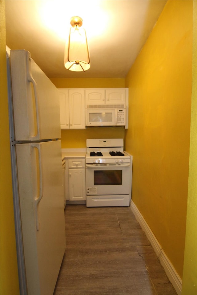 kitchen featuring white cabinets, dark hardwood / wood-style flooring, and white appliances