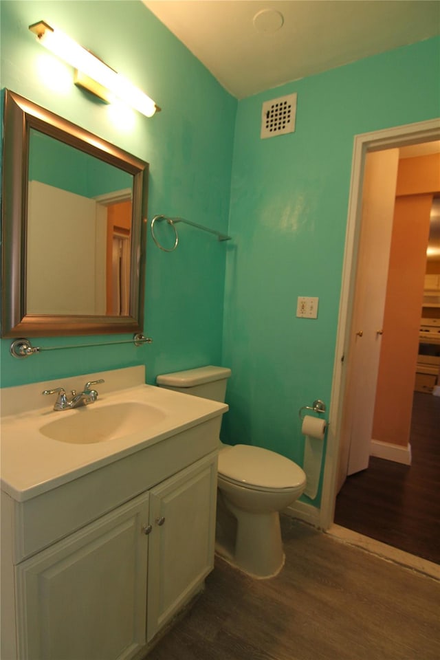 bathroom featuring hardwood / wood-style floors, vanity, and toilet