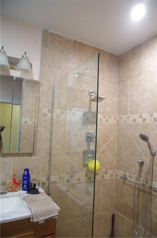 bathroom featuring decorative backsplash, a tile shower, and vanity