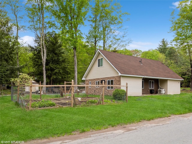 view of side of property with a garden, a yard, and roof with shingles