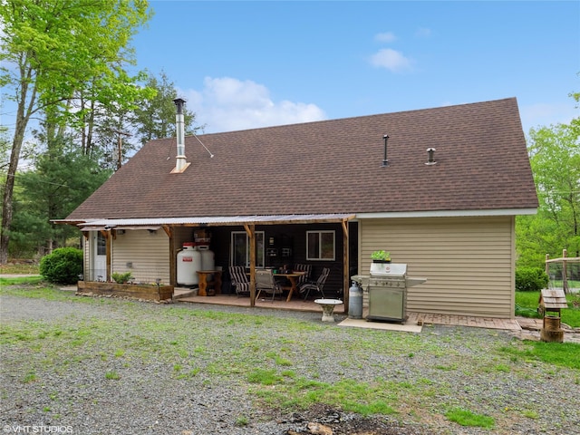 back of property featuring roof with shingles