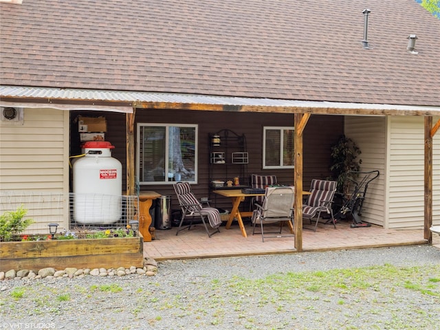 back of house with roof with shingles and a patio