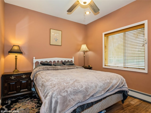 bedroom with a baseboard radiator, wood finished floors, and a ceiling fan