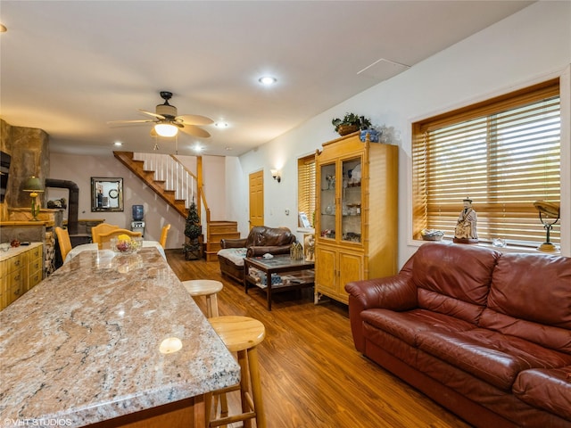 living area with wood finished floors, stairway, a ceiling fan, and recessed lighting