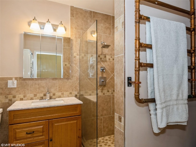 bathroom with tiled shower, vanity, and toilet