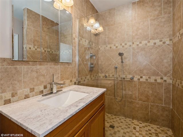 bathroom with a tile shower and vanity