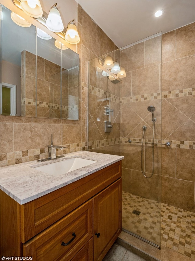 full bathroom featuring a tile shower, vanity, and recessed lighting