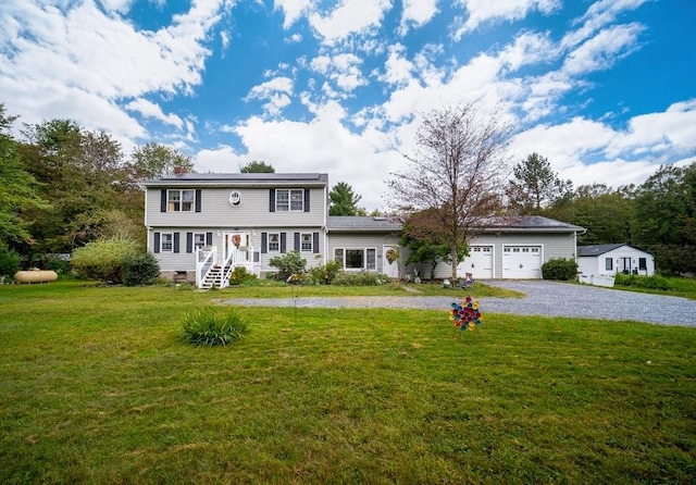 colonial home with a front yard and a garage