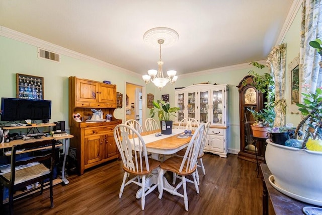 dining room featuring crown molding, dark hardwood / wood-style flooring, and a chandelier