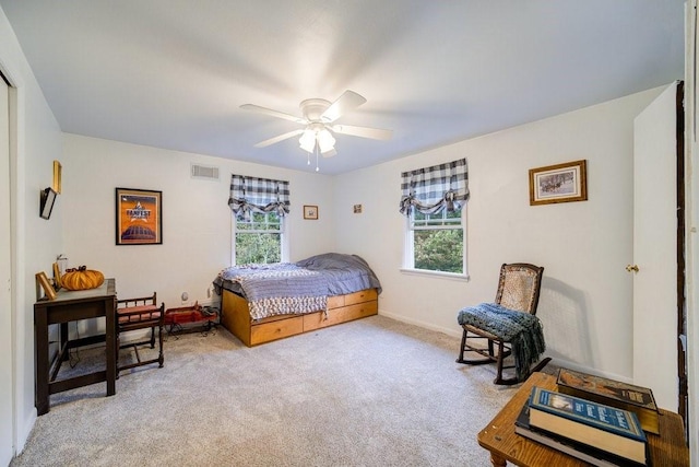 bedroom featuring light colored carpet, multiple windows, and ceiling fan