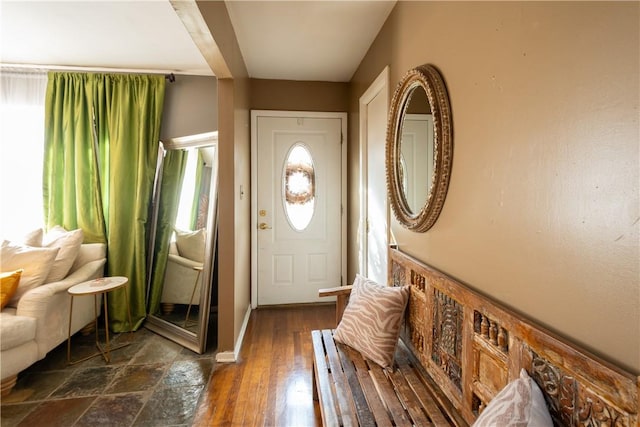 foyer entrance with beamed ceiling and dark hardwood / wood-style floors