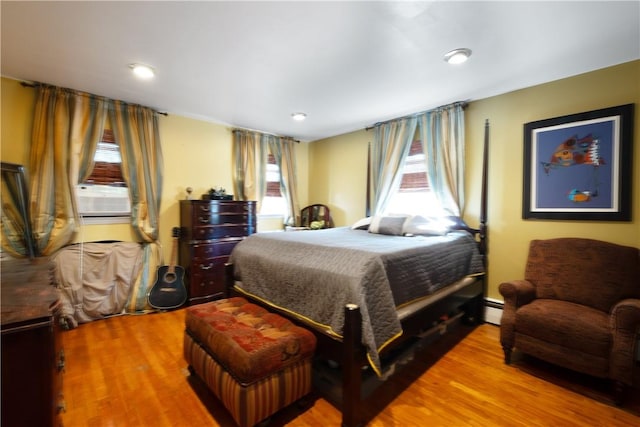 bedroom with wood-type flooring and multiple windows