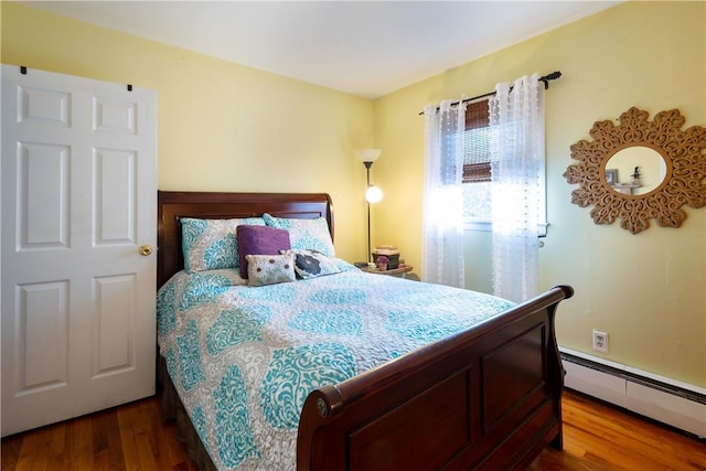 bedroom featuring hardwood / wood-style flooring and a baseboard radiator