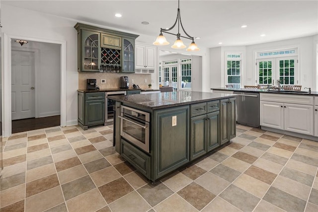 kitchen featuring french doors, tasteful backsplash, dark stone counters, stainless steel appliances, and a kitchen island