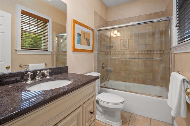 full bathroom with toilet, vanity, tile patterned floors, and enclosed tub / shower combo