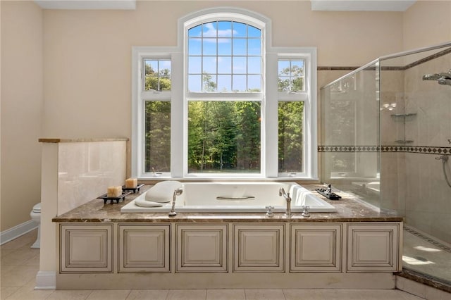 bathroom featuring tile patterned flooring, toilet, and independent shower and bath