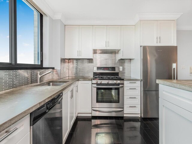 kitchen with white cabinetry, sink, crown molding, decorative backsplash, and appliances with stainless steel finishes