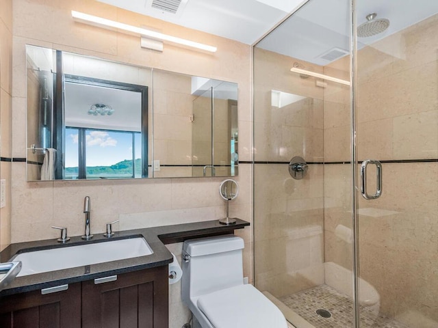 bathroom featuring an enclosed shower, vanity, toilet, and tile walls