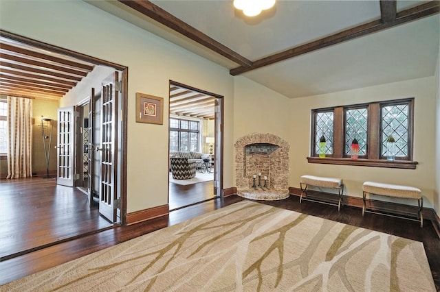 living area featuring beam ceiling, dark hardwood / wood-style floors, and french doors