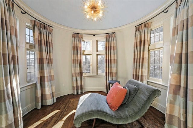 living area with crown molding, dark hardwood / wood-style flooring, and a notable chandelier