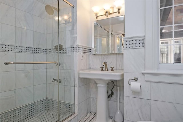 bathroom featuring a shower with door and tile walls