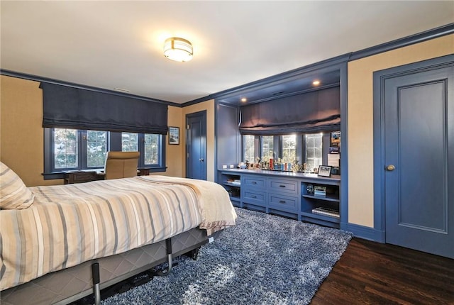 bedroom with bar area, multiple windows, dark hardwood / wood-style floors, and ornamental molding