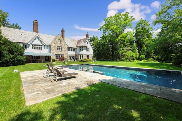 view of swimming pool featuring a yard and a patio