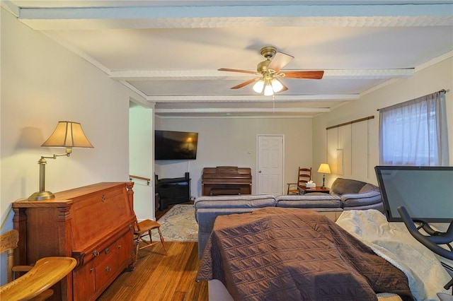 bedroom featuring hardwood / wood-style flooring, ceiling fan, and beamed ceiling