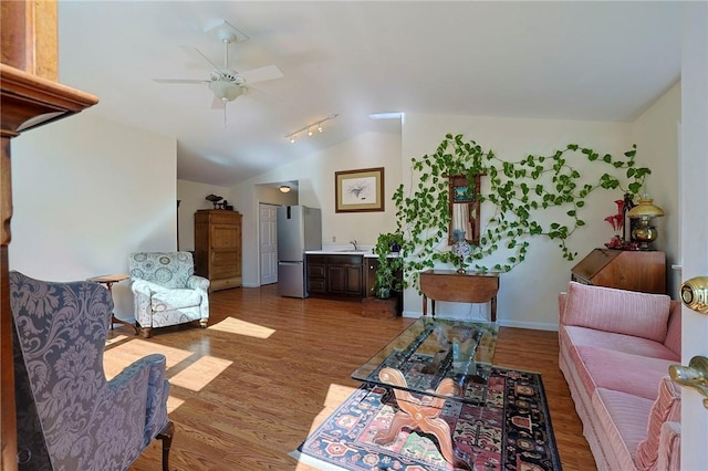 living room featuring ceiling fan, hardwood / wood-style floors, lofted ceiling, and sink