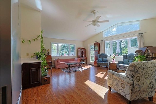 living room with ceiling fan, wood-type flooring, and vaulted ceiling