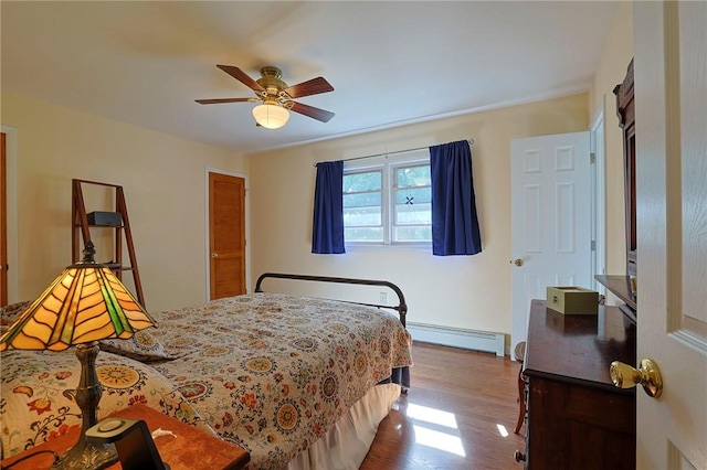 bedroom with hardwood / wood-style floors, a baseboard radiator, and ceiling fan