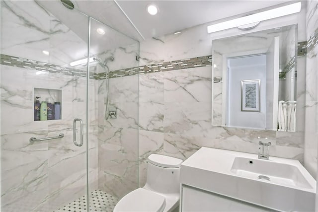 bathroom featuring walk in shower, vanity, toilet, and tile walls