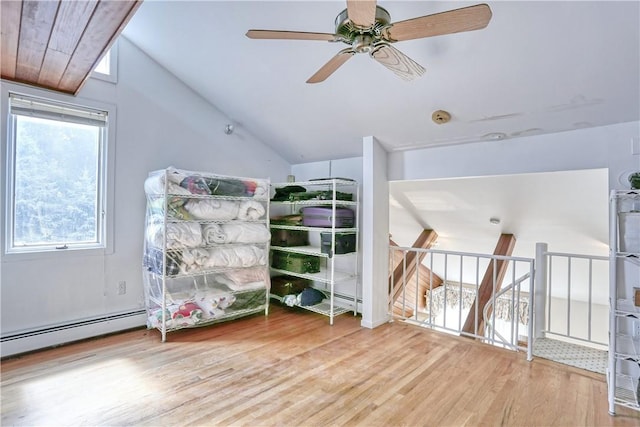 bedroom with a baseboard radiator, vaulted ceiling, and hardwood / wood-style flooring