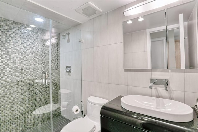 bathroom featuring tasteful backsplash, an enclosed shower, toilet, vanity, and tile walls