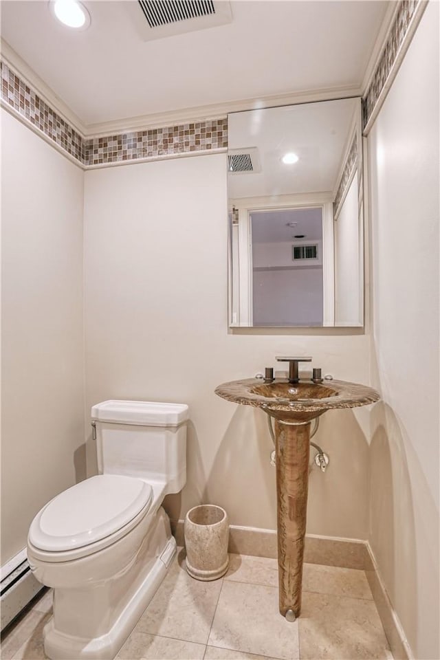 bathroom featuring tile patterned flooring, toilet, and a baseboard heating unit