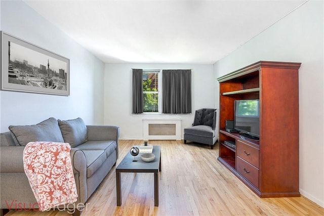 living room with radiator and light hardwood / wood-style flooring