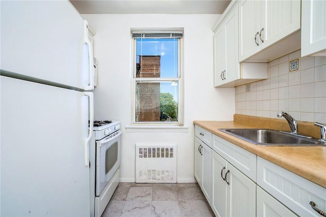 kitchen with backsplash, radiator, white appliances, sink, and white cabinetry